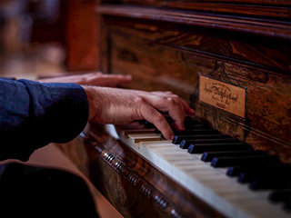 Photo de Pau Fernández Benlloch au clavier du piano à queue dans l’auditorium Ad Libitum